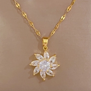 Close-up of titanium steel gold flower pendant necklace with micro-set sparkling crystals