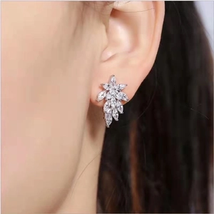 Close-up of silver teardrop hoop earring with crystal inlay on model's ear