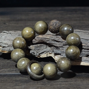 Gros plan de perles en bois phoebe doré 20mm avec gravure de caractères sur écorce