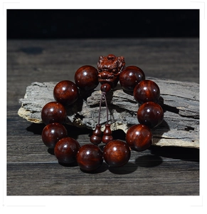 Gros plan détaillé d'un bracelet en bois de santal avec Pixiu sculpté sur bois vieilli