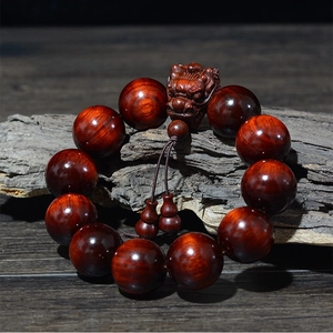 Détail des perles en bois de rose de 20mm avec un accessoire sculpté en tête de dragon