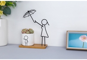 Modern iron silhouette art planter with a wooden base and white ceramic succulent pot