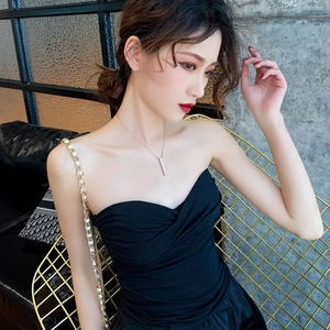 Close-up of a vertical gold bar pendant necklace worn elegantly on a woman collarbone
