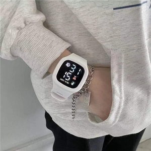 Detail of white digital LED watch worn with silver chain bracelet on a wrist