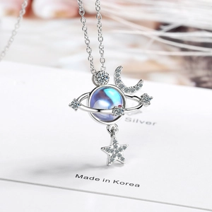 Star and moon planet necklace in silver with blue gemstone on white background