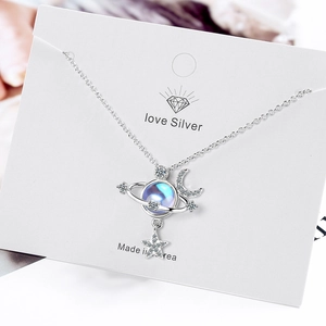 Celestial necklace with moon, star, and blue moonstone pendant on a silver chain
