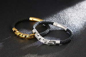 Detail of woven black leather bracelets with polished gold and silver stainless steel clasps