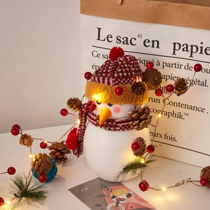 LED felt snowman decor with warm copper wire lights, pine cones and red berries ornaments