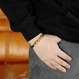 Men's titanium steel chain bracelet with black leather cord on a leather background