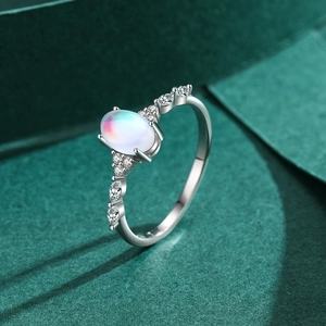 Elegant s925 silver oval moonstone ring with sparkling side stones on green background