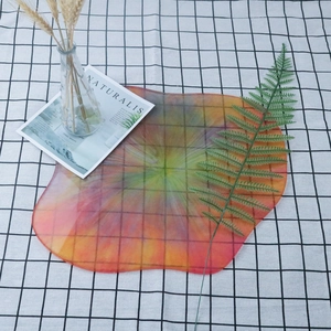 Irregular cloud-shaped colorful resin tray with iridescent swirl textures on plaid background