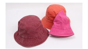 Close-up of vintage washed cotton bucket hats in burgundy, orange, and rose pink