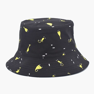 Detailed close-up of cotton bucket hat with yellow and white abstract print on black fabric
