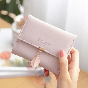 Close-up of pale pink PU leather trifold wallet with leaf pendant and metal buckle