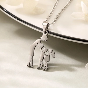 Detailed view of silver mother and two children heart pendant on white plate