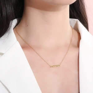 18k gold plated stainless steel MAMA letter pendant necklace worn by a female model