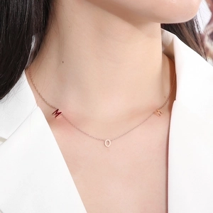 Detail of rose gold MOM letter necklace pendant worn on neck for Mother's Day gift