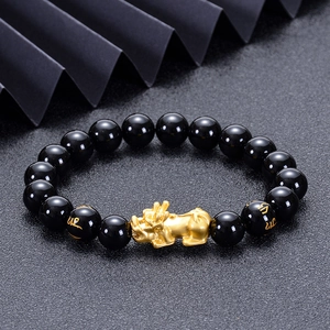 Close-up of black obsidian beads with golden Pixiu charm and mantra engravings