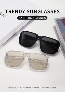 Detail of square oversized sunglasses with gold accents on black and champagne frames