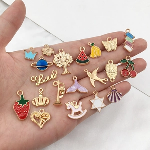 Macro shot of 20 assorted gold enamel charms for DIY jewelry making with fruit and heart motifs
