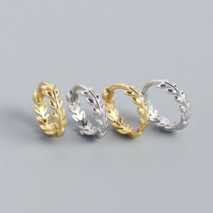 Detalle macro de pendientes de hoja de trigo en oro y plata con circón de marquesa