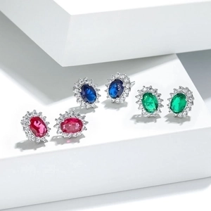 Classic sunburst halo stud earrings with ruby, sapphire, and emerald oval gemstones