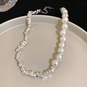 Minimalist silver irregular metal beads and white faux pearls necklace displayed on a tray