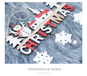 Detail of wooden Christmas door hanger with snowman, houses and hanging snowflakes