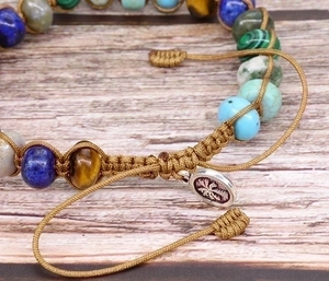 Detail of colorful imperial stone beaded yoga bracelet with palm tree metal charm
