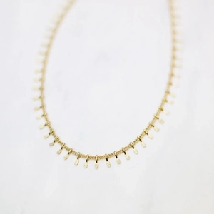 Elegant gold link necklace featuring textured oval pineapple-patterned pendants on marble