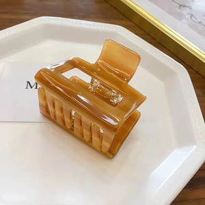 Detail of amber marble pattern rectangular hair claw clip on a decorative tray