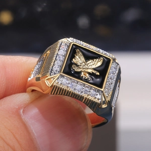 Men's gold plated eagle ring with black enamel and white zircon accents shown on finger
