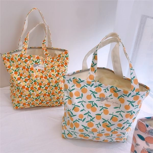 Détail du sac à main en coton avec imprimés d'oranges et fermeture éclair métallique