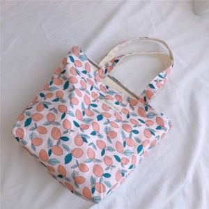 Détail du sac cabas en toile rose avec imprimé agrumes et étiquette en tissu blanc