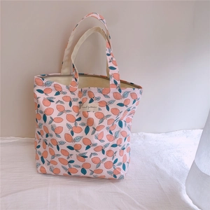 Gros plan détaillé d'un sac à main en coton rose avec motifs floraux de citrons
