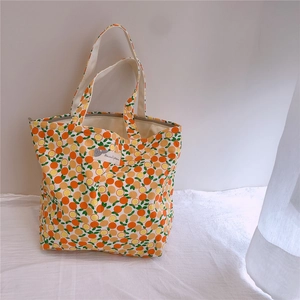 Sac fourre-tout en toile avec imprimés d'agrumes orange et étiquette blanche sur fond tissu