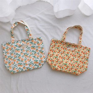 Détail de sacs en coton avec imprimés agrumes orange et fermetures éclair chic