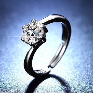 Close-up of a six-prong crown setting solitaire moissanite ring with adjustable silver band