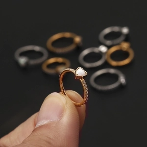 Golden stainless steel heart ring featuring white opal stone and pavé zircon accents
