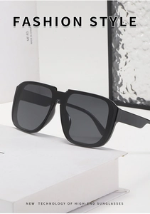 Close-up of oversized square sunglasses featuring flat top frames and dark grey lenses
