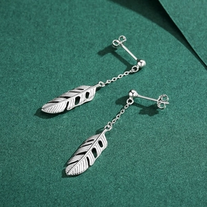 Elegant S925 sterling silver feather drop earrings on a dark green textured background