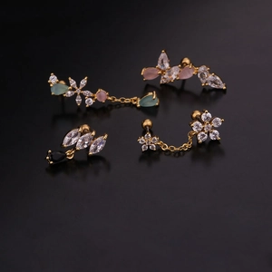 Detail of floral gold earrings set with multicolor teardrop cubic zirconia on dark background