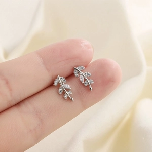 Detailed macro view of S925 sterling silver leaf stud earrings with sparkling cubic zirconia