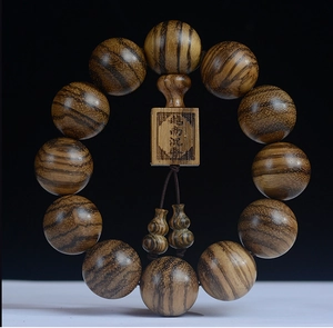 Macro detail of natural yellow-brown wood grain on 108 agarwood prayer beads bracelet
