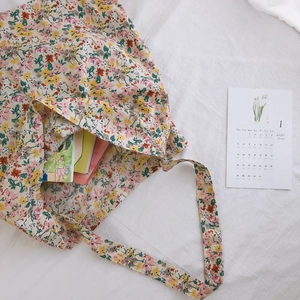 Floral cotton tote bag with vintage patterns and internal books on a white soft background
