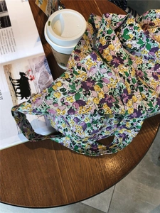 Flat lay of floral cotton tote bag with purple flowers on a wooden table setup