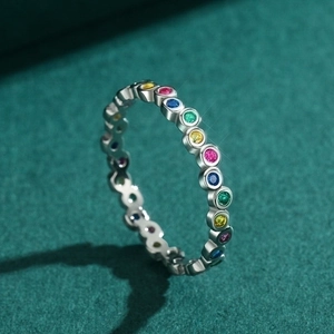 S925 sterling silver eternity ring featuring colorful round rainbow stones on green surface