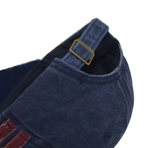 Detail of adjustable metal buckle and washed cotton texture on navy blue baseball cap