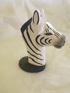 Detailed view of hand-carved zebra wood glasses holder with painted black and white stripes