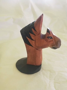 Macro shot of hand-carved wooden horse glasses holder with geometric faceted design